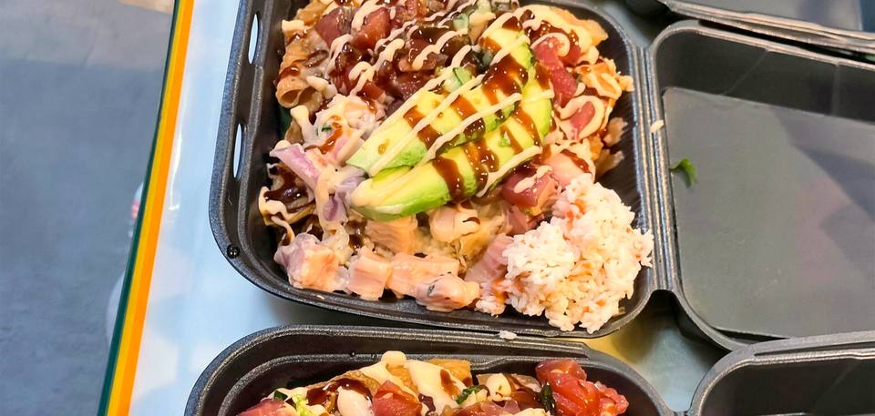 Trays of poke nachos and shrimp tempura nachos ready for pickup