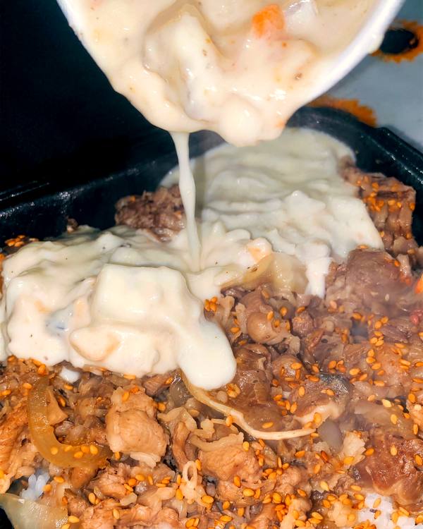 Creamy clam chowder poured over a beef and rice bowl